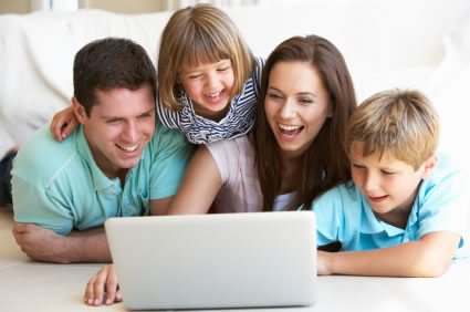 幸福的四口之家看着笔记本电脑